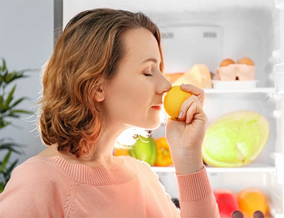 woman smelling an orange