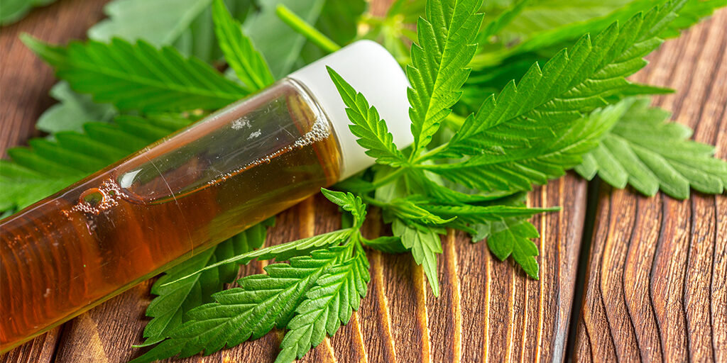 cannabis-leaves-and-oil-on-wood-table cannabis leaves and oil on wood table